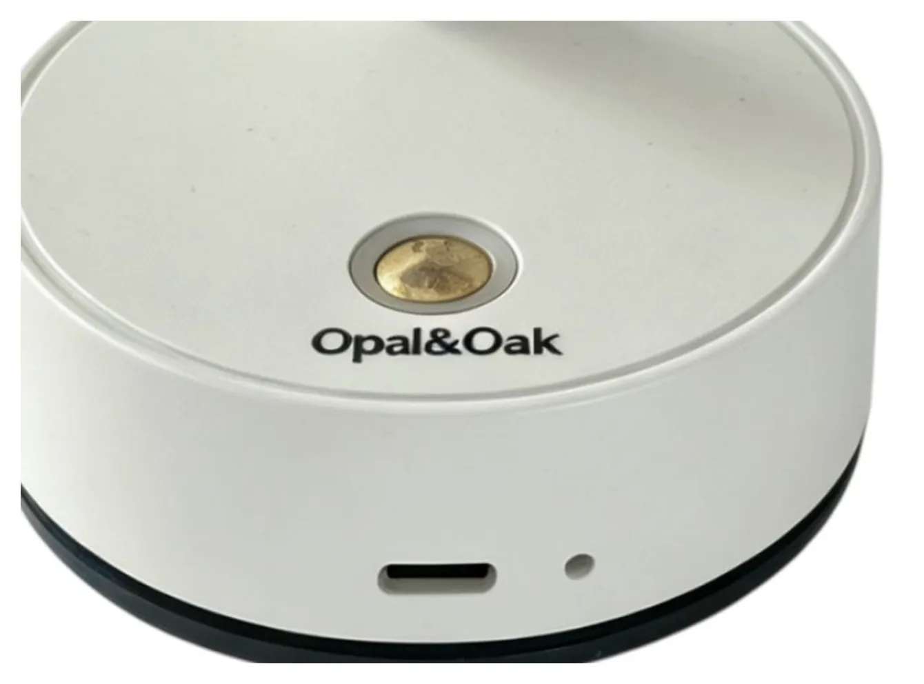 The Opal&Oak name printed on the base of the white spotlight, beside the brass switch