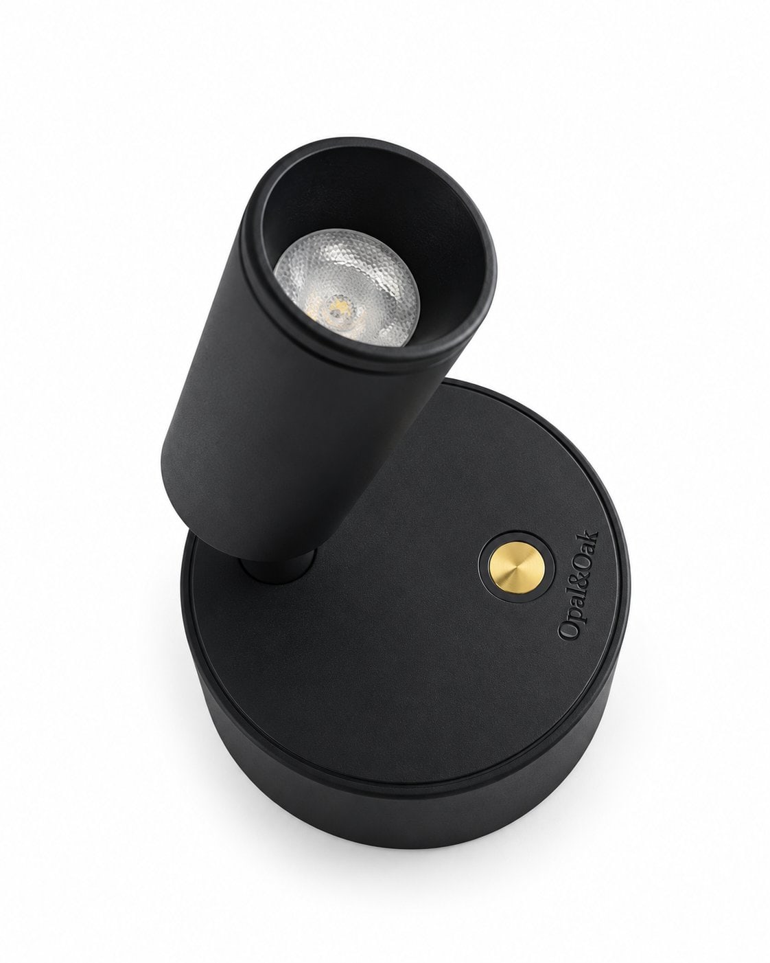 The same spotlight seen from above at an angle, its head tipped forward and the brass switch and brand name on the base both in view