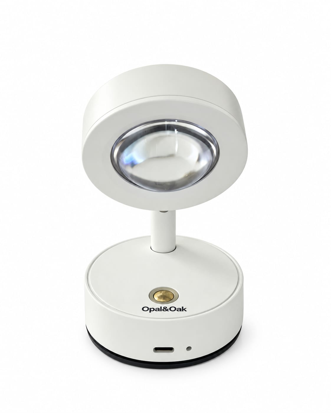 The white Opal&Oak rechargeable spotlight, angled so the lens, the brass switch on its base and the brand name printed beneath it are all in view